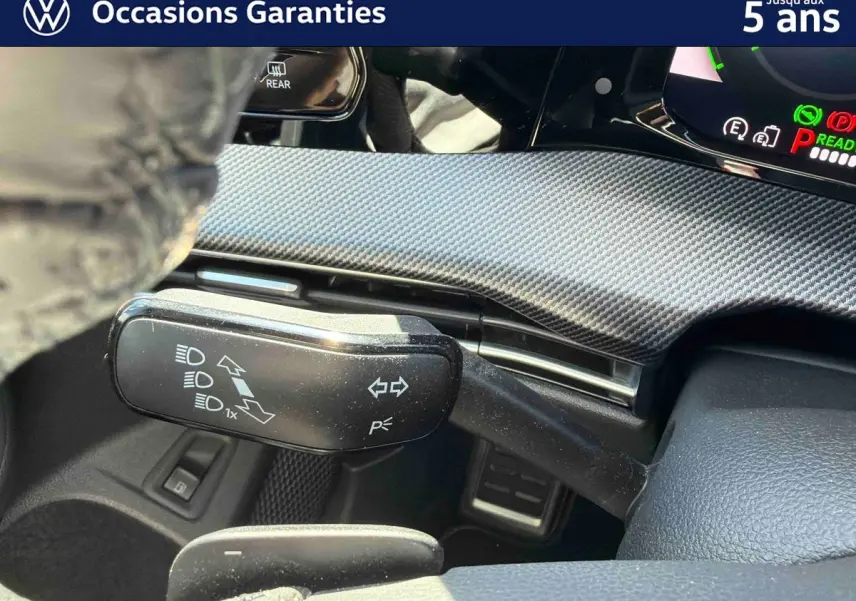 Détail du commodo gauche avec commandes d’éclairage et volant cuir sport dans une Volkswagen Golf 1.5 eHybrid 2025.