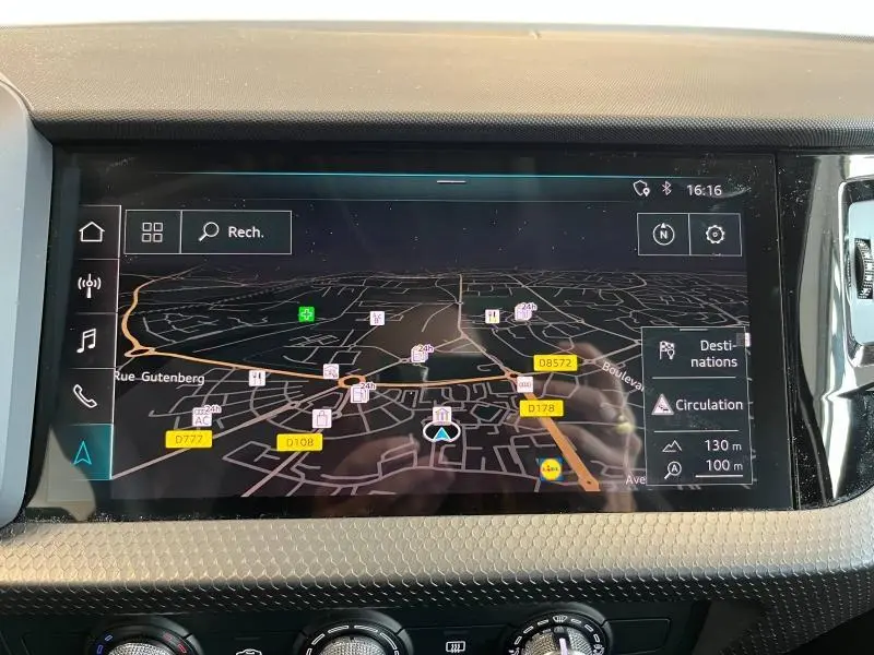 Écran tactile central de navigation GPS dans l'habitacle d'une Audi A1 Sportback noire, affichant une carte détaillée.