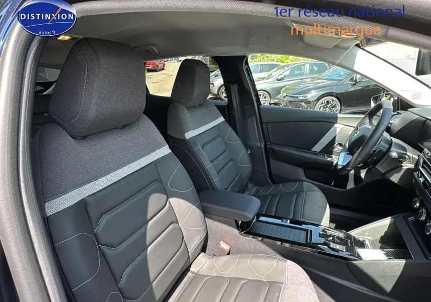 Intérieur de la Citroën C4 1.5 BlueHDi 130, vue côté gauche, sièges bi-matière gris et noir avec accoudoir central.