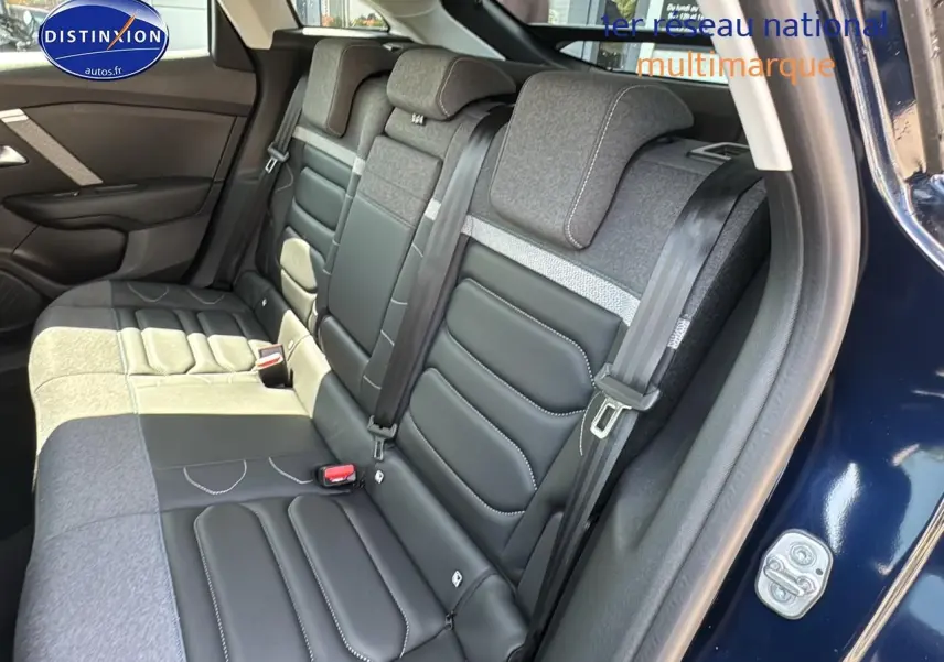Vue côté droit sur la banquette arrière bicolore cuir et tissu du Citroën C4 bleu eclipse avec ceinture de sécurité visible.