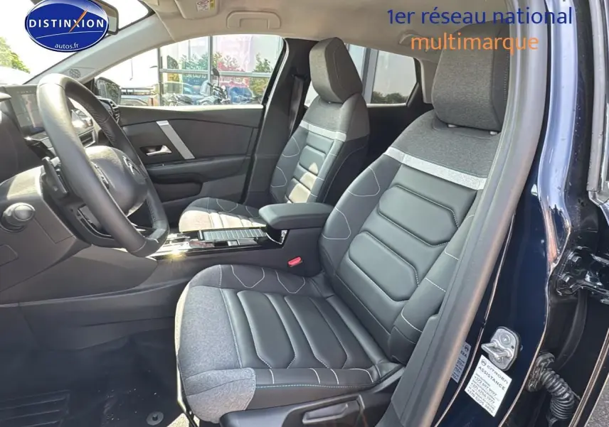 Intérieur avant droit de la Citroën C4 bleu eclipse, sièges bi-matière cuir et tissu avec accoudoir central.