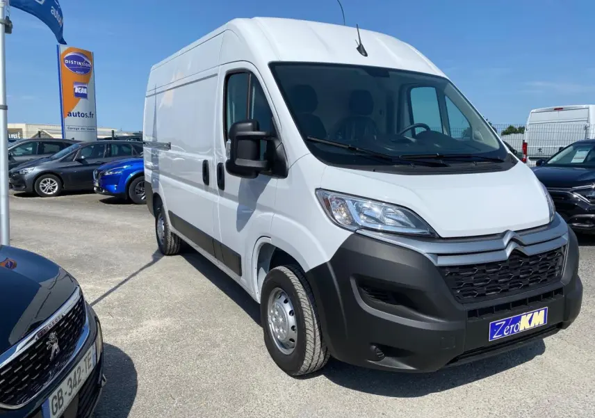 Fourgon blanc Citroën Jumper 3.5t L2H2 vu en 3/4 avant droit sur parking ensoleillé