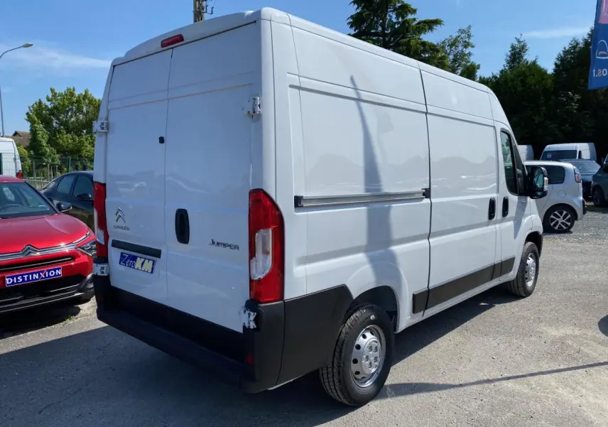 Vue 3/4 arrière droite d'un utilitaire Citroën Jumper blanc avec portes arrière tôlées et jantes acier.
