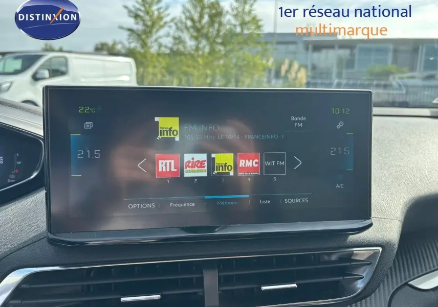Écran tactile central du Peugeot 3008 gris platinium 2022 affichant les stations radio FM dans un habitacle moderne.