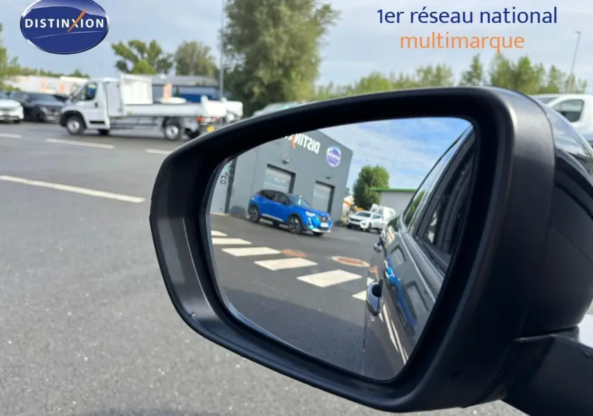 Rétroviseur côté droit montrant la carrosserie gris platinium du Peugeot 3008 hybride rechargeable 2022 en extérieur.