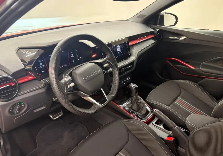 Vue intérieure côté conducteur de la Skoda Fabia Monte Carlo 2025, avec finitions rouges et volant multifonction.