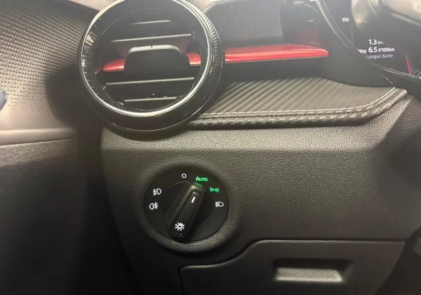 Détail du tableau de bord côté gauche de la Skoda Fabia 2025, avec aérateur rond et commande des phares en mode auto.