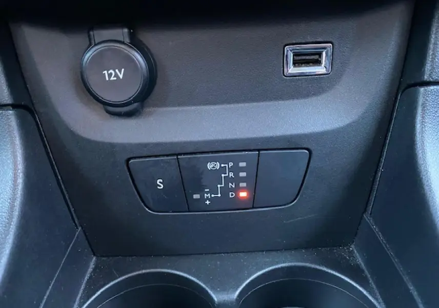 Gros plan sur la commande de boîte automatique et prise USB dans l'habitacle noir de la Citroën C3 Shine 2023.