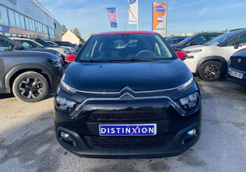 Citroën C3 Shine 2023 noir avec toit rouge, vue de face mettant en valeur les phares LED et la calandre distinctive.