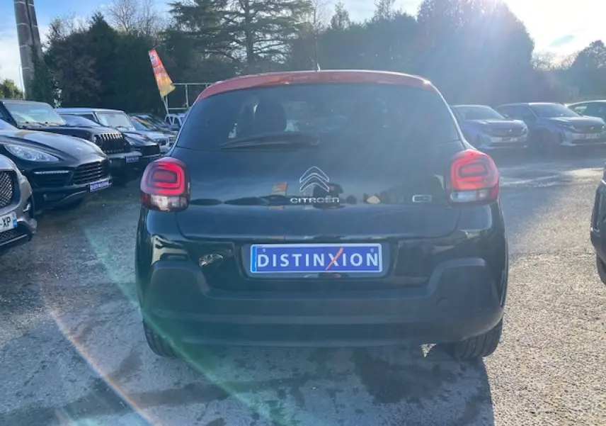Vue arrière d'une Citroën C3 noire avec toit rouge, feux arrière LED et plaque d'immatriculation Distinxion.