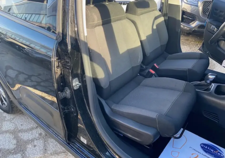 Vue intérieure côté gauche des sièges avant noirs d'une Citroën C3 Shine 2023 avec porte ouverte.