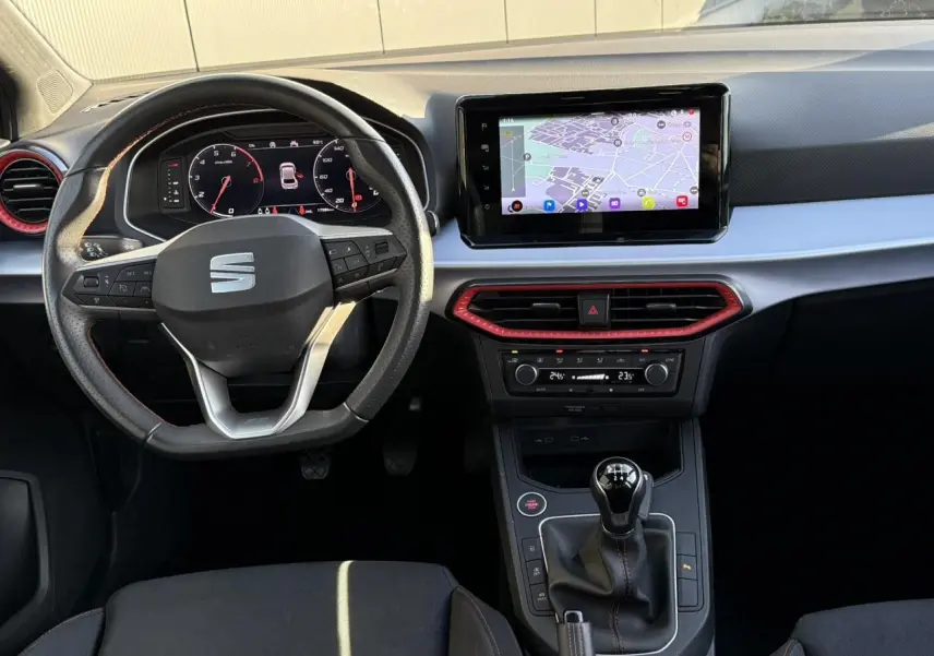 Intérieur de la SEAT IBIZA TSI 115 FR 2025, vue du tableau de bord avec écran tactile et levier de vitesses manuel.