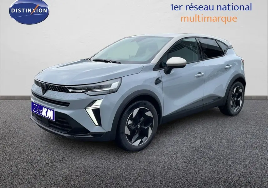 Renault Captur 2025 gris Rafale métal avec toit beige, vue 3/4 avant droit mettant en valeur ses jantes noires stylisées.