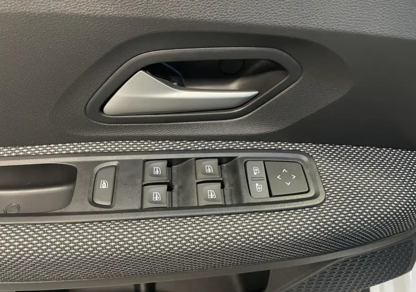 Gros plan sur la commande des lève-vitres et rétroviseurs côté conducteur du Dacia Sandero Stepway blanc glacier.