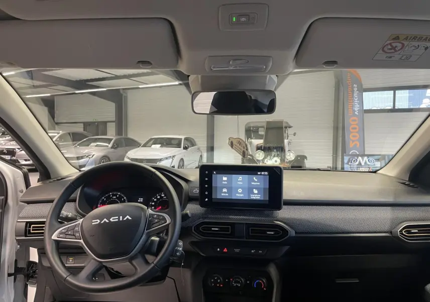 Intérieur avant de la Dacia Sandero TCe 90 Stepway 2025, tableau de bord noir avec écran tactile central.