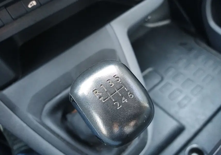 Gros plan sur le levier de vitesses manuel noir du Citroën Jumpy blanc, avec marquage des six rapports et marche arrière.