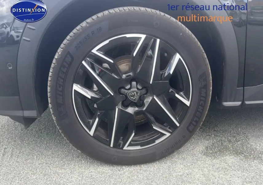 Gros plan sur la jante alu noire et argentée du Peugeot 5008 Hybrid 145 allure e-dcs6 noir, avec pneu Michelin visible.