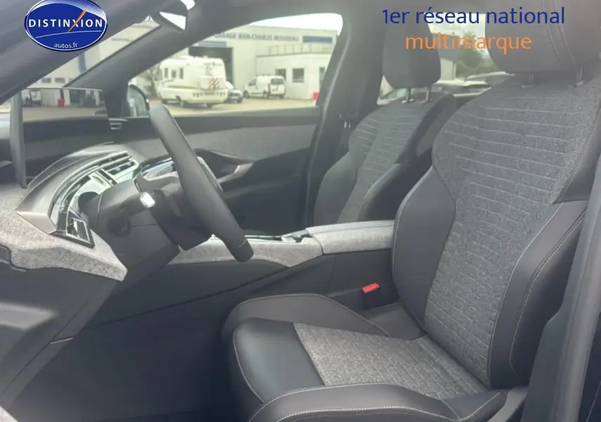 Vue intérieure côté conducteur du Peugeot 5008 Hybrid 145 allure e-dcs6 2025, sièges tissu gris et cuir noir.