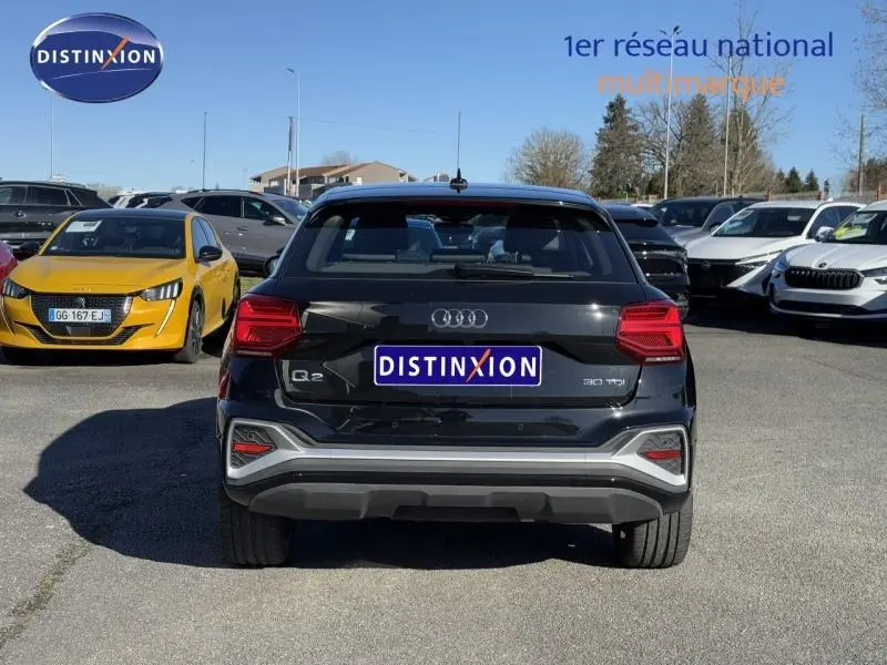 Vue arrière d'un Audi Q2 30 TDI S line noir Mythic métallisé, avec feux LED et bouclier couleur caisse.
