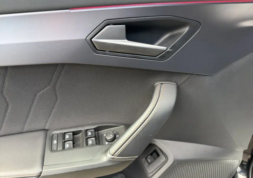 Gros plan sur la porte côté conducteur de la CUPRA Formentor 2025, avec poignée alu et commandes électriques noires.