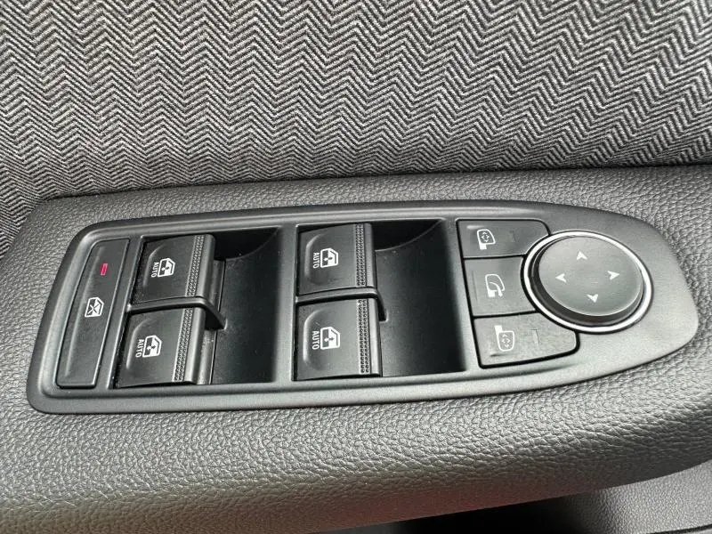 Gros plan sur les commandes de lève-vitres et rétroviseurs côté gauche intérieur de la Renault Clio 1.0 Eco-G 2025.