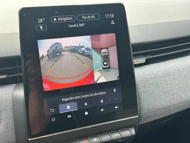 Écran tactile intérieur montrant la caméra 360° avec vue arrière et vue plongeante du véhicule rouge Flamme Renault Clio.