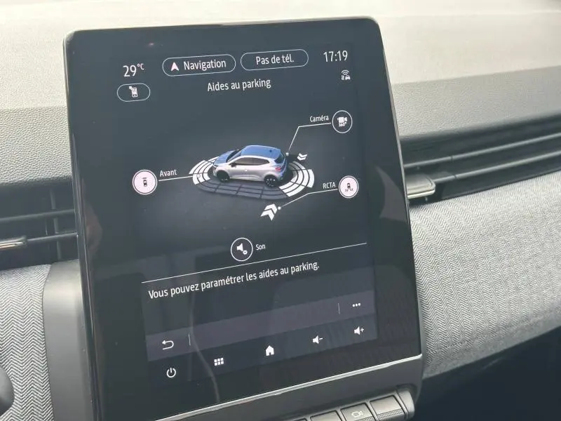 Écran tactile central affichant l'aide au parking dans une Renault Clio rouge Flamme, intérieur gris.