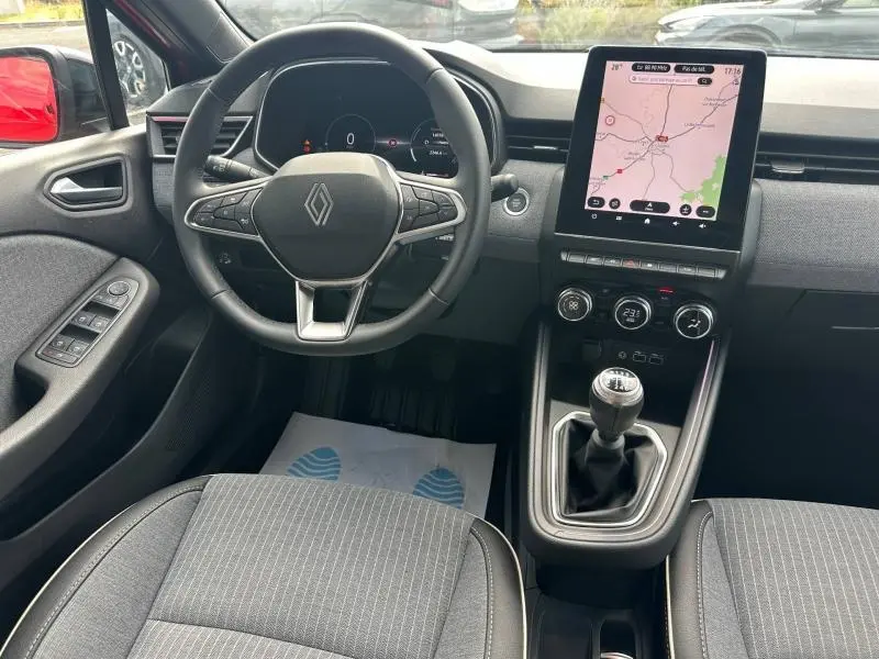 Vue intérieure avant de la Renault Clio 1.0 Eco-G 100ch Techno 2025, volant multifonction, écran tactile vertical et levier de vitesse manuel.