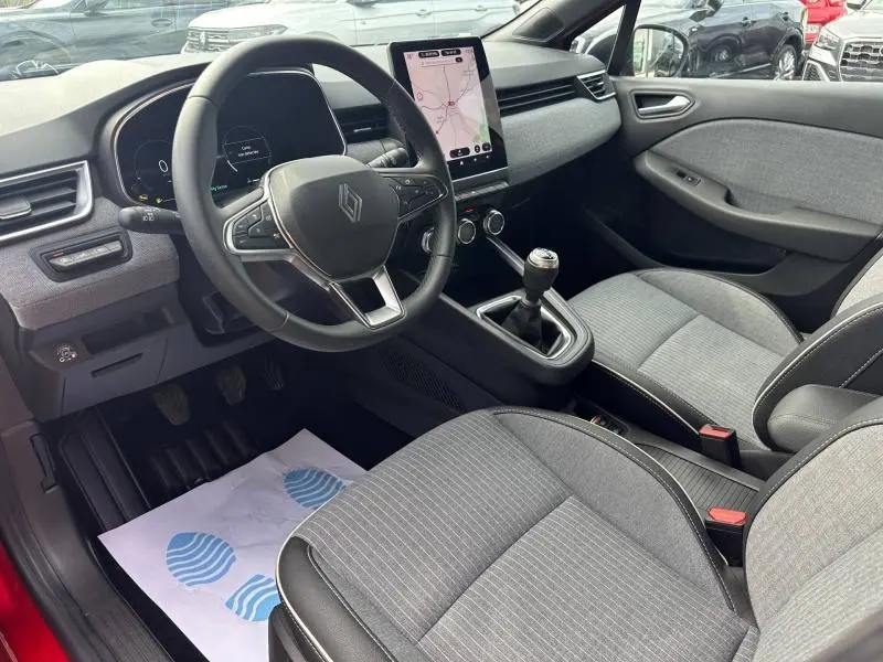 Intérieur de Renault Clio 1.0 Eco-G 100ch Techno 2025, vue côté conducteur, sièges gris et écran tactile vertical.