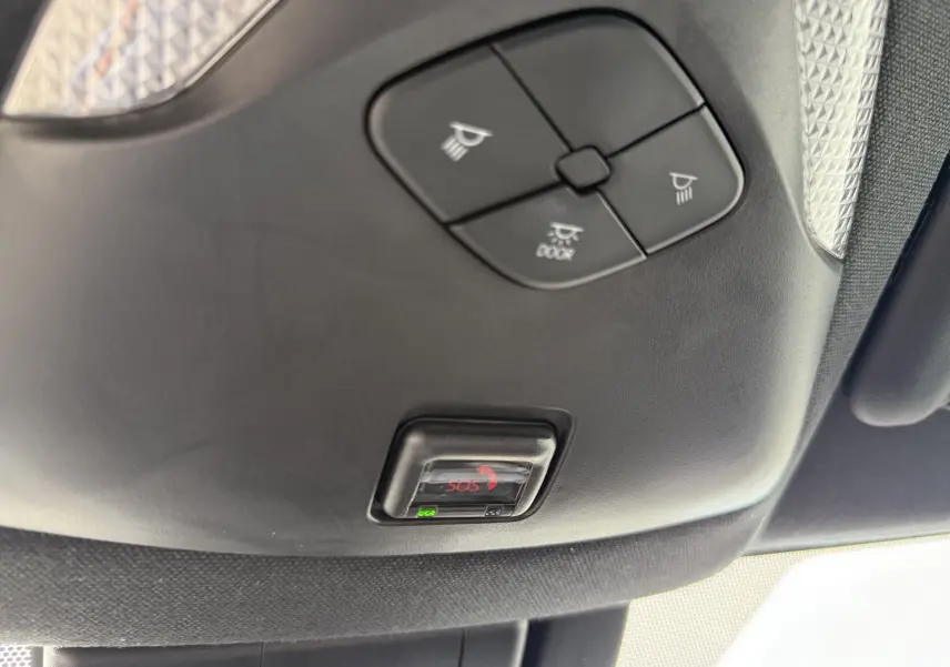 Vue en gros plan du plafonnier noir avec commandes d’éclairage et bouton SOS du Toyota C-HR hybride gris atlas 2023.