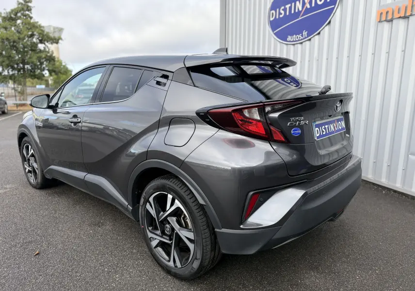 Vue 3/4 arrière droite du Toyota C-HR 1.8 hybrid gris atlas, soulignant ses lignes dynamiques et ses jantes bi-ton.