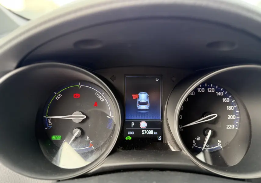 Tableau de bord du Toyota C-HR hybride gris atlas 2023, affichage digital central avec porte avant gauche ouverte.