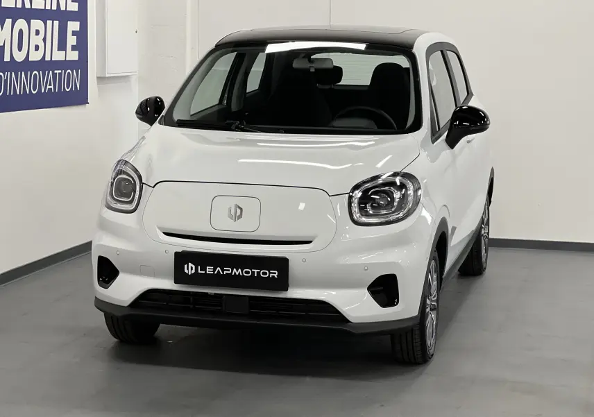 Vue de face d'une Dacia Spring blanche version Leap Motor T03 avec calandre fermée et phares arrondis LED.