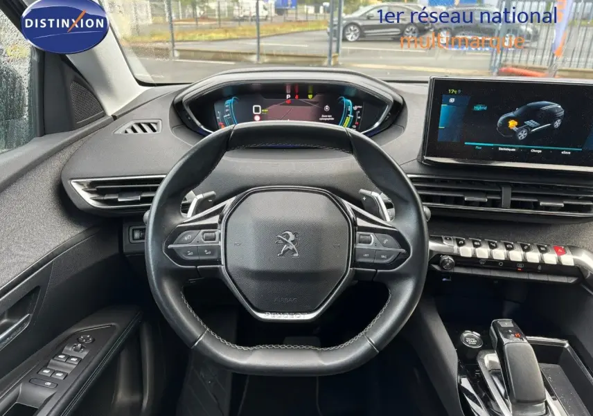 Vue intérieure centrée sur le volant Peugeot 3008 hybride 2022 avec tableau de bord numérique et écran tactile.