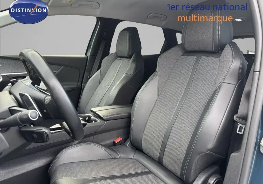 Intérieur du Peugeot 3008 hybride 2022, vue côté conducteur, sièges en cuir et tissu gris, ambiance moderne et soignée.
