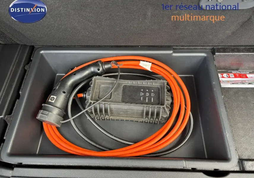 Câble de recharge orange enroulé dans le coffre du Peugeot 3008 hybride rechargeable bleu Célèbes.