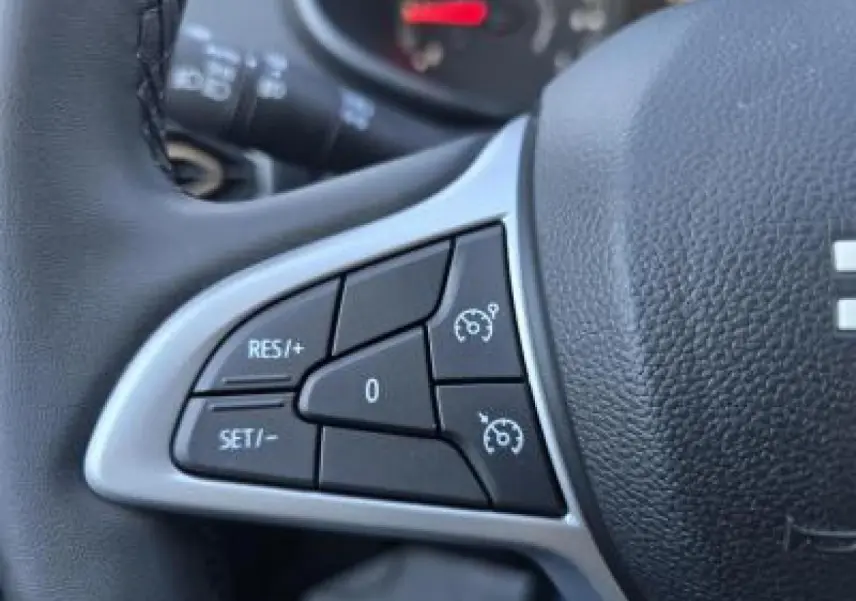 Gros plan sur les commandes du régulateur de vitesse au volant cuir noir du Dacia Sandero Stepway 2025.