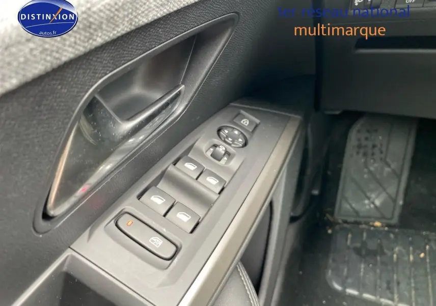 Gros plan sur les commandes des vitres électriques côté gauche d’un Peugeot 5008 gris titane, intérieur noir.