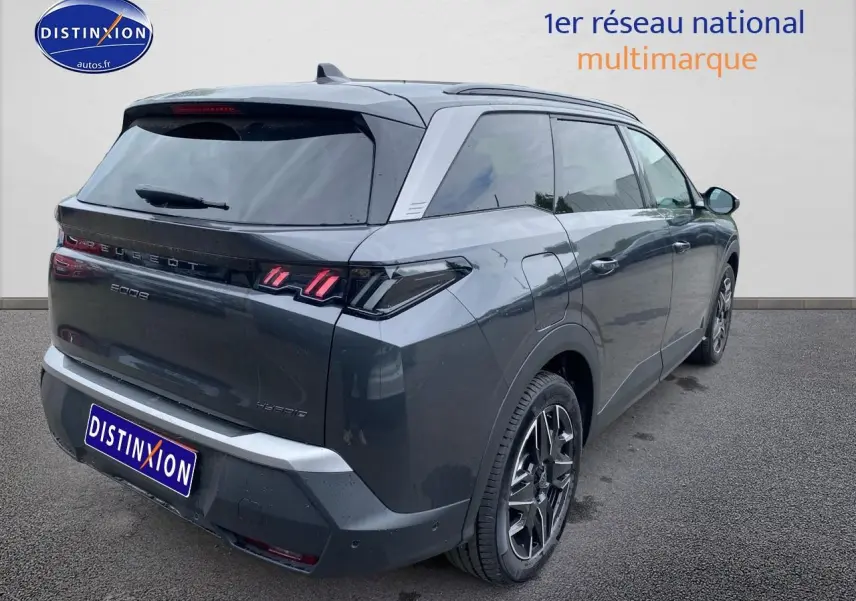 Vue 3/4 arrière droite d’un Peugeot 5008 Hybrid 145 allure gris titane avec feux arrière LED et jantes alu.