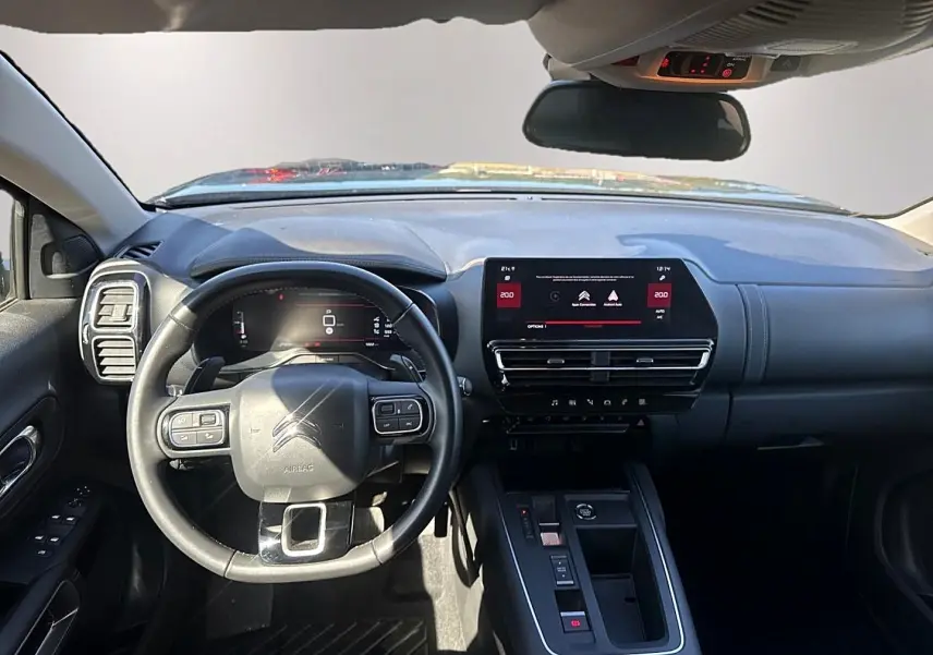 Vue intérieure avant du tableau de bord noir du Citroën C5 Aircross 1.2 hybride avec écran tactile et volant multifonction.