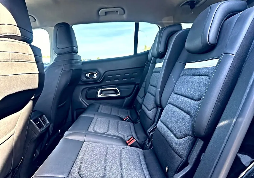 Vue intérieure de la 2e rangée de sièges individuels noirs et gris du Citroën C5 Aircross hybride 2025.