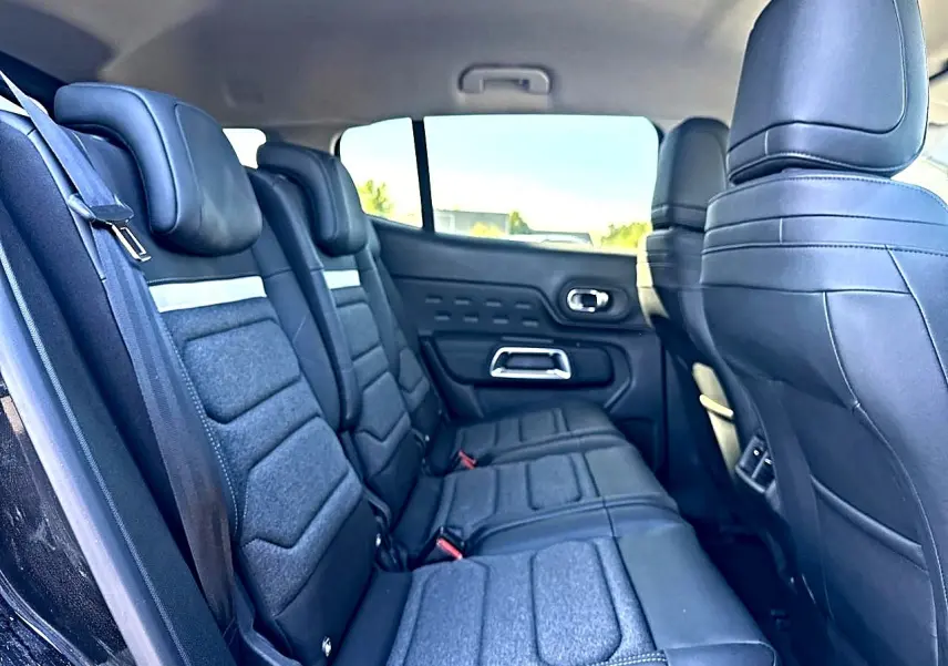 Vue latérale gauche de la 2e rangée de sièges noirs en tissu et cuir du Citroën C5 Aircross 2025 hybride.