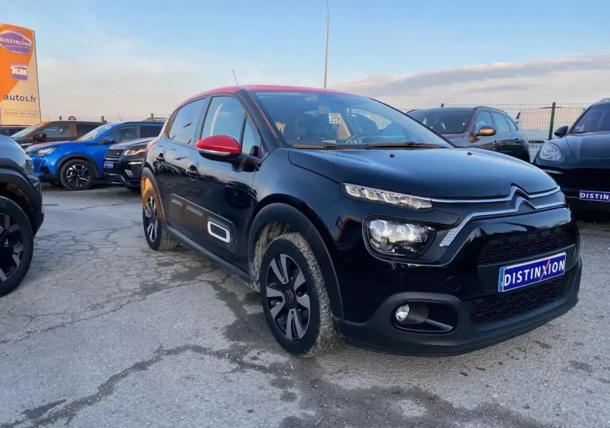 Citroën C3 Shine 2023 noir avec toit et rétroviseurs rouges, vue 3/4 avant droit sur parking.
