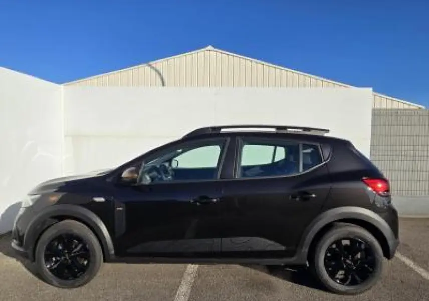 Profil côté gauche de la Dacia Sandero III Stepway noir nacré avec barres de toit et jantes noires en aluminium.