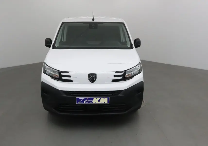 Vue de face d’un Peugeot Partner blanc 2025 avec calandre noire et logo lion central, dans un studio neutre.