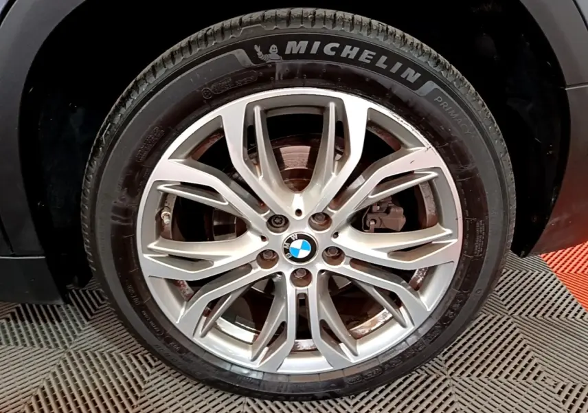 Gros plan sur la roue avant droite du BMW X2 hybride rechargeable, jante alliage argentée avec pneu Michelin.
