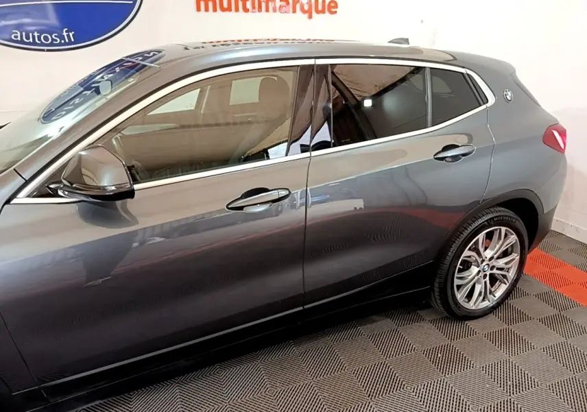 Vue latérale droite d'un BMW X2 hybride rechargeable gris métallisé avec jantes alliage et rétroviseurs assortis.
