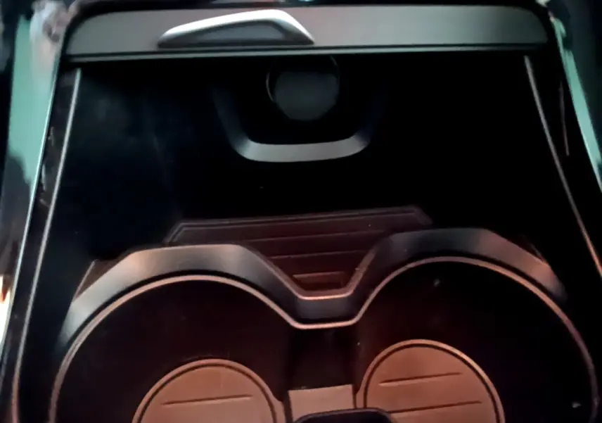 Gros plan sur les porte-gobelets noirs au centre de la console d'une BMW X2 hybride rechargeable 2020.