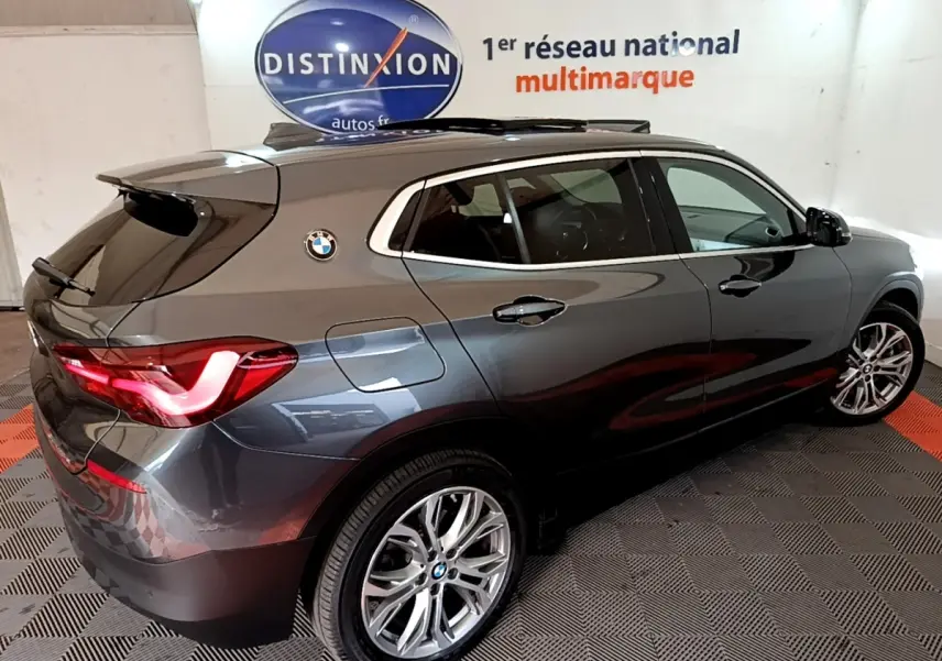Vue 3/4 arrière droite d’un BMW X2 hybride rechargeable gris métallisé avec feux LED et jantes alliage.