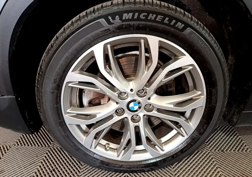 Gros plan sur la jante alliage argentée et pneu Michelin d'une BMW X2 xDrive25e hybride rechargeable, côté avant droit.